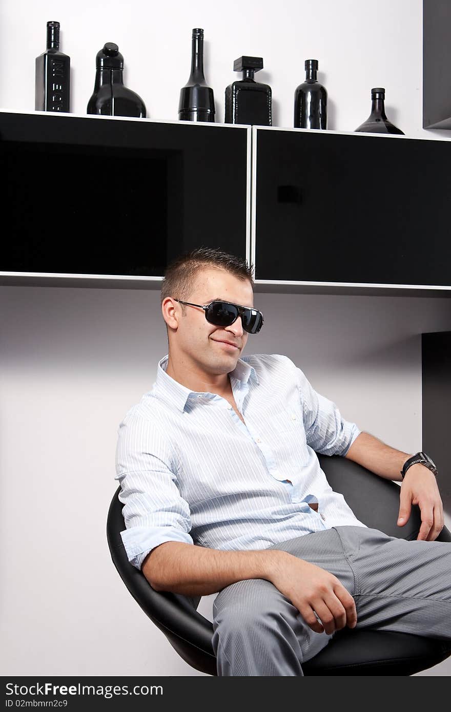 Young man with sunglasses sitting on an armchair