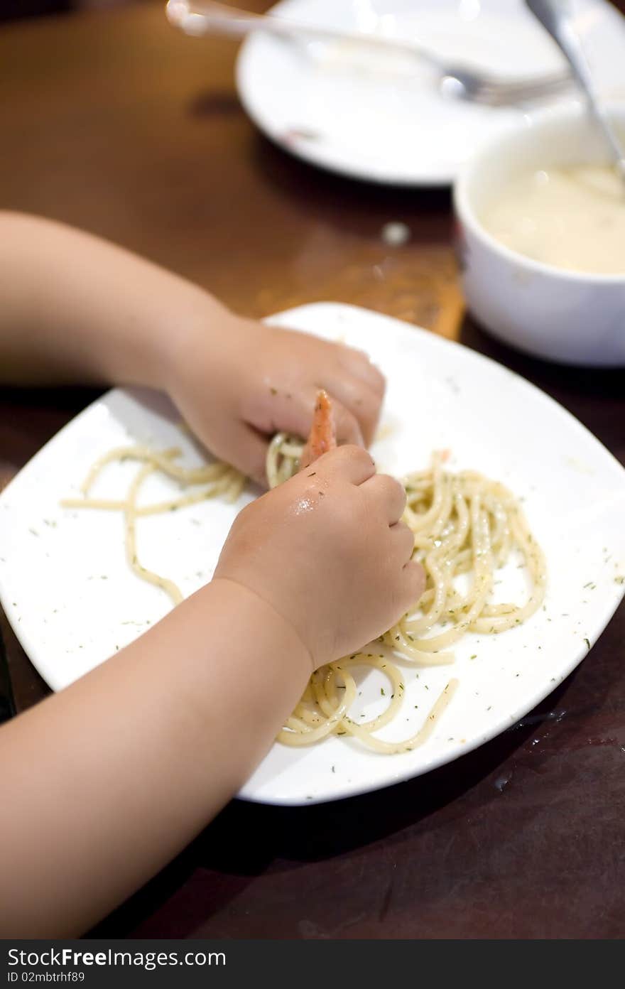 Eating baby to grab pasta in a restaurant