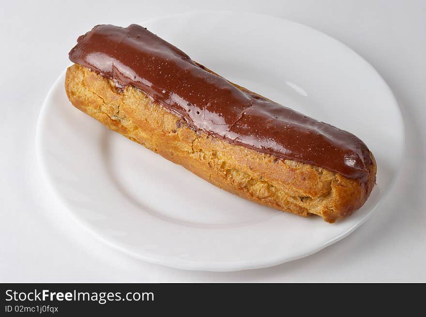 Glazed eclair macro shot over grey gradient background