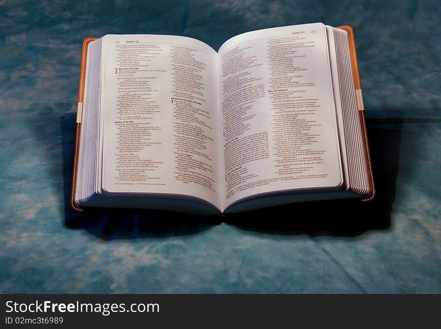 An open Bible sitting on a blue background.