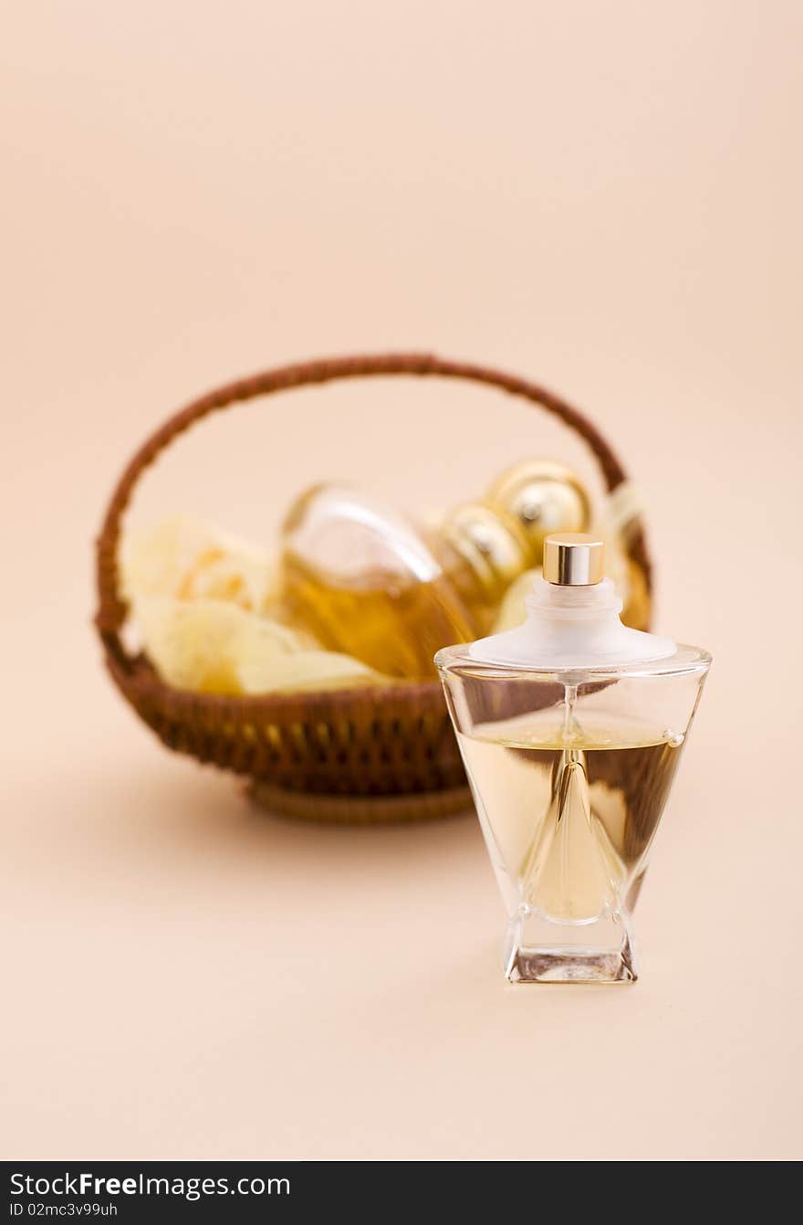 A glass bottle of perfume and fragrances in the basket