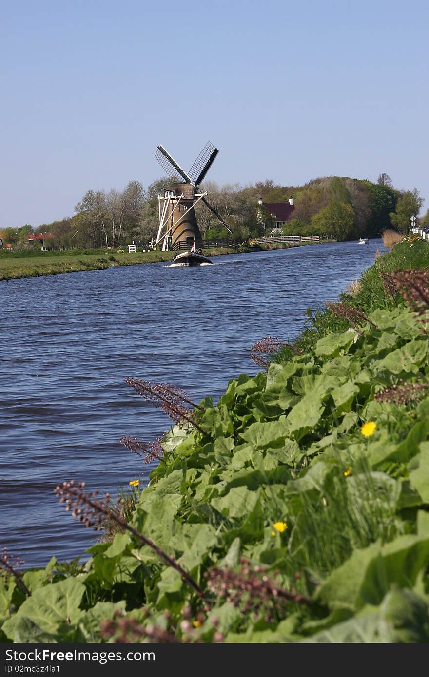 Windmill alongside canal.