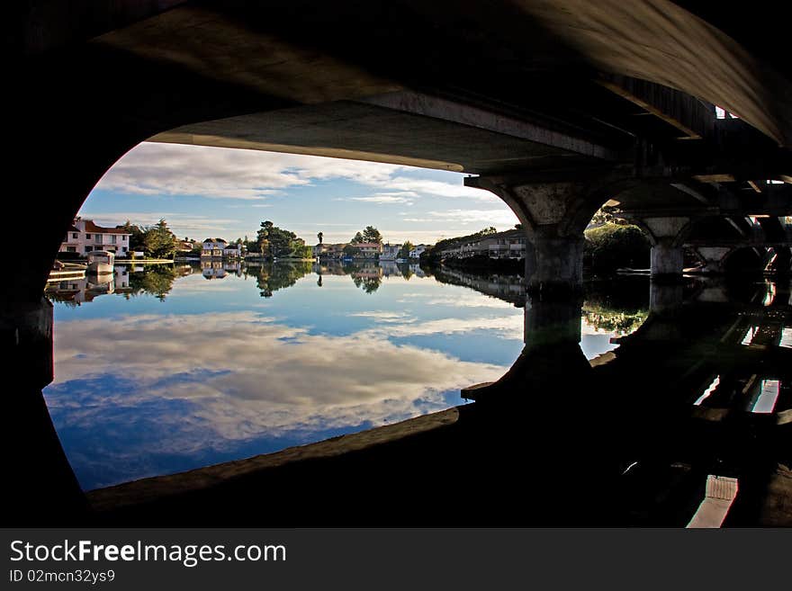 Neighborhood and sky with reflections viewed from under a bridge. Neighborhood and sky with reflections viewed from under a bridge