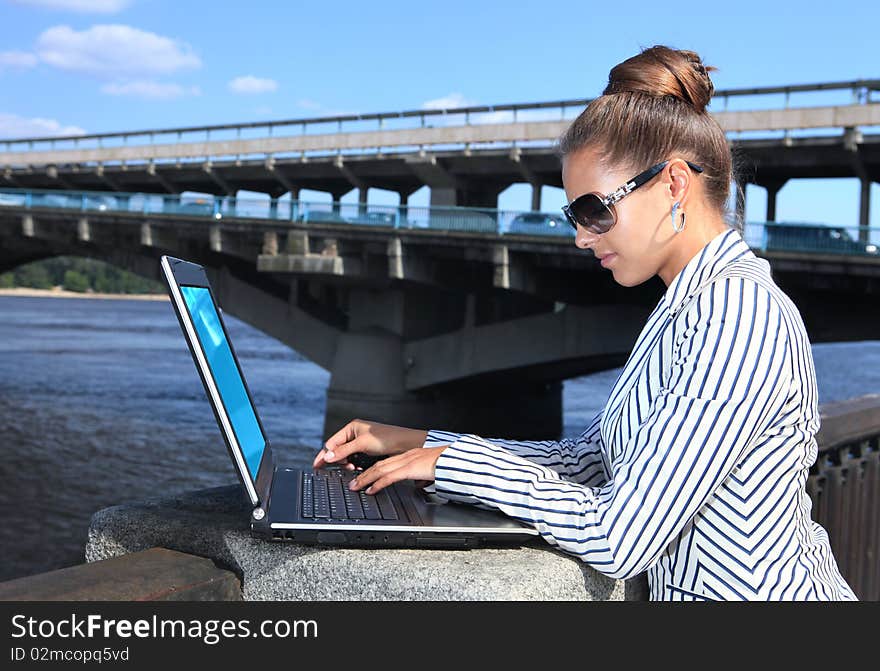 Businesswoman with laptop on quay