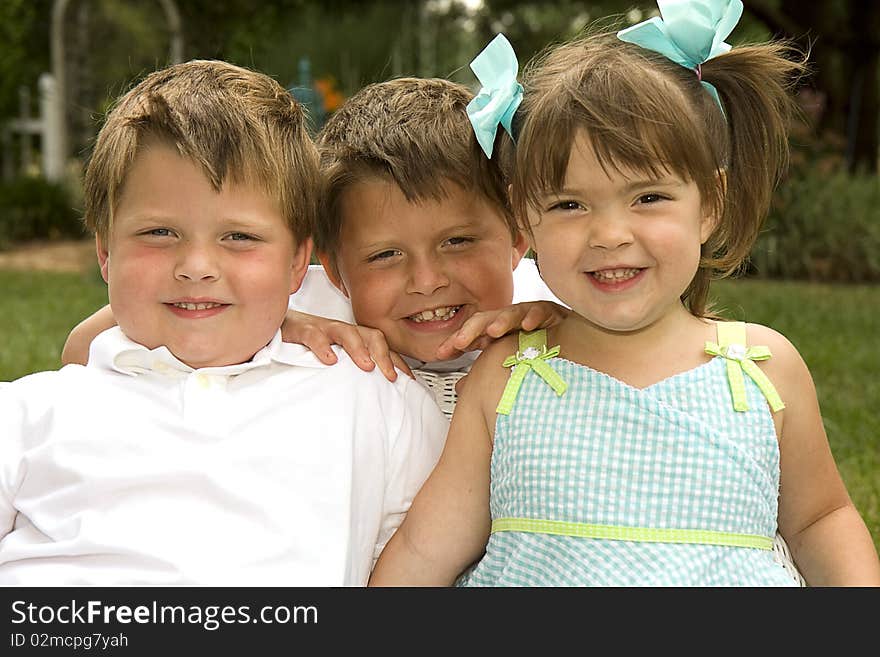 Brothers and sister having fun outside and smiling big