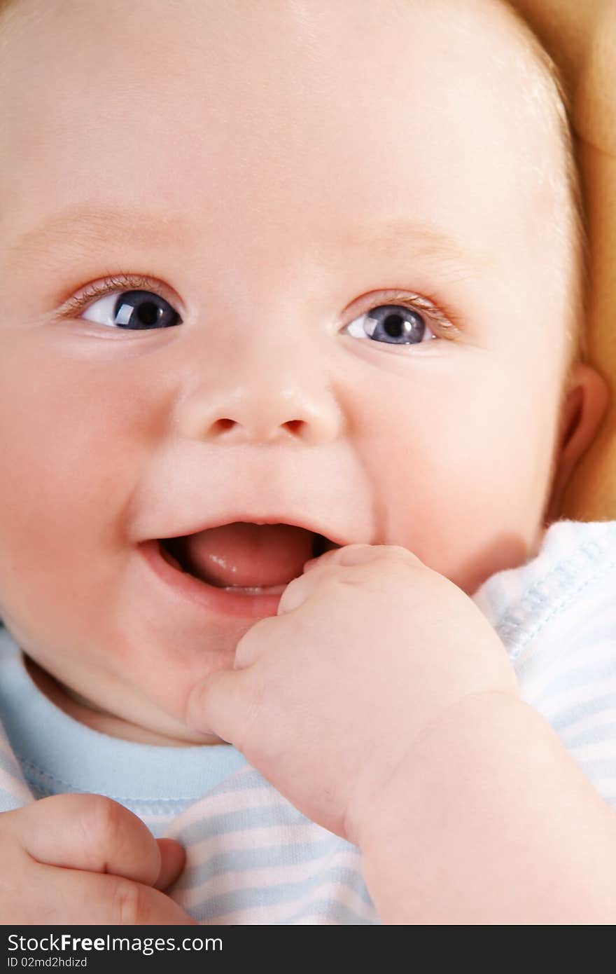 Portrait of happy laughing baby-boy with blue eyes, studio shot