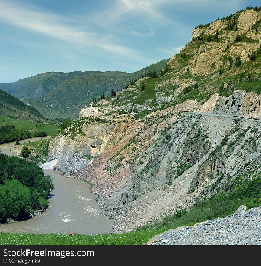 The mountain river flows among vegetation. The mountain river flows among vegetation