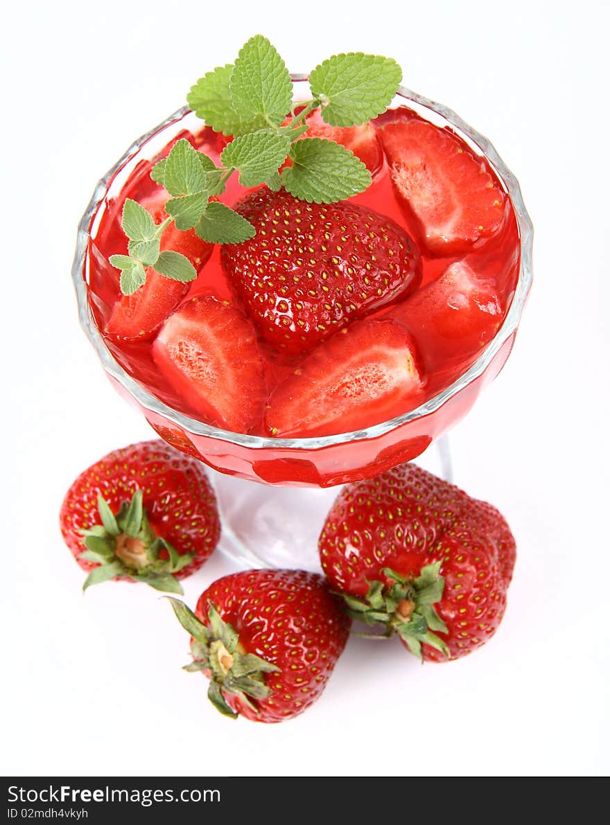 Jelly with strawberries decorated with a lemon balm twig and three strawberries