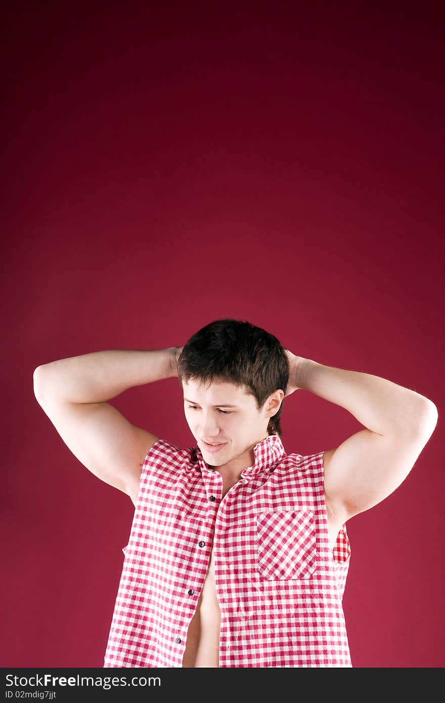 Adult sports guy looks down on a red background. Adult sports guy looks down on a red background