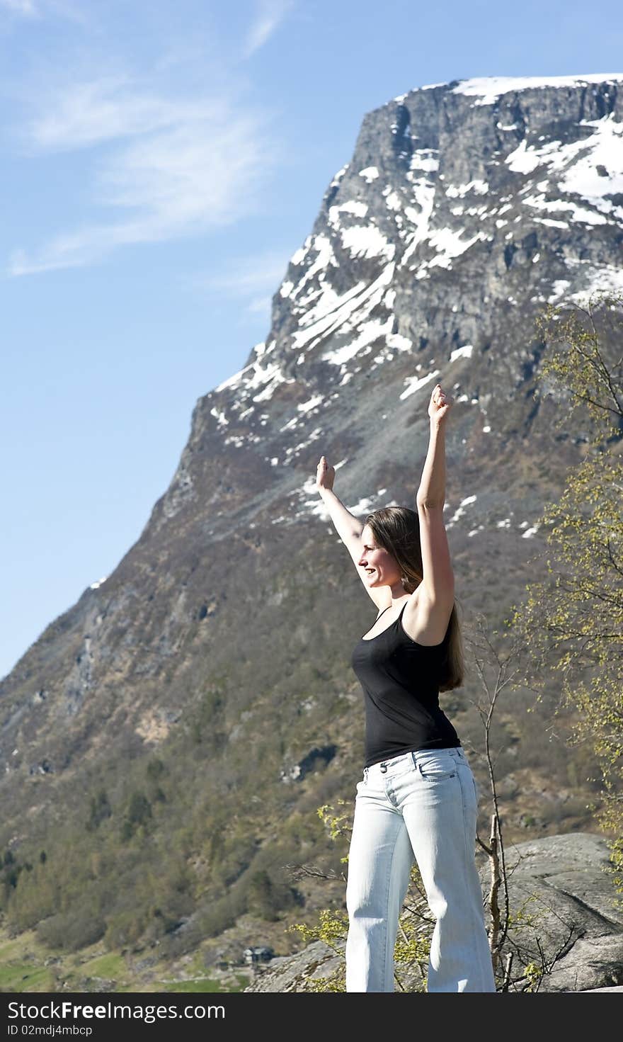 Woman hiker raising up her arms in the air on a mountain after. Woman hiker raising up her arms in the air on a mountain after