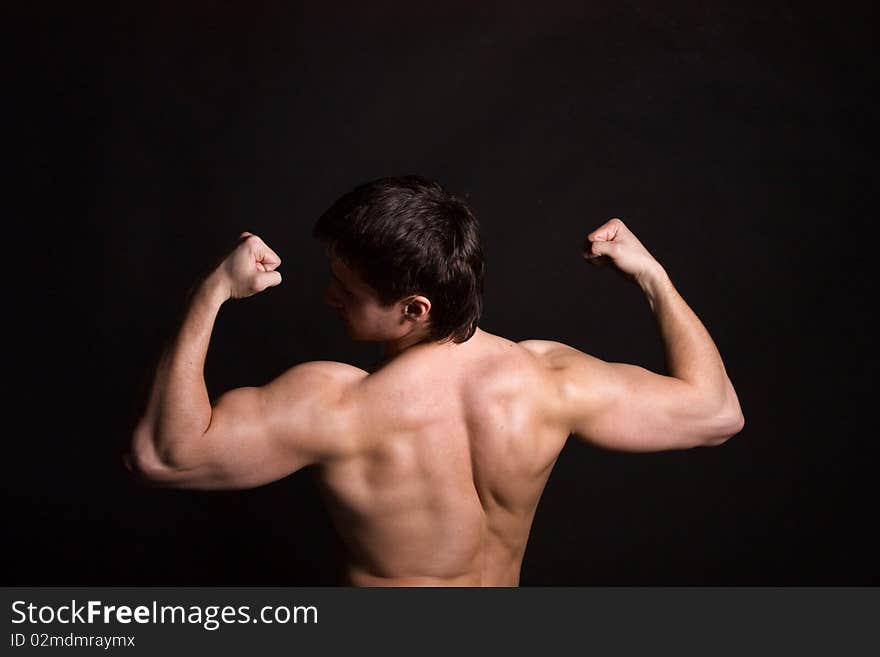 Back of sexy muscular man, isolated on black