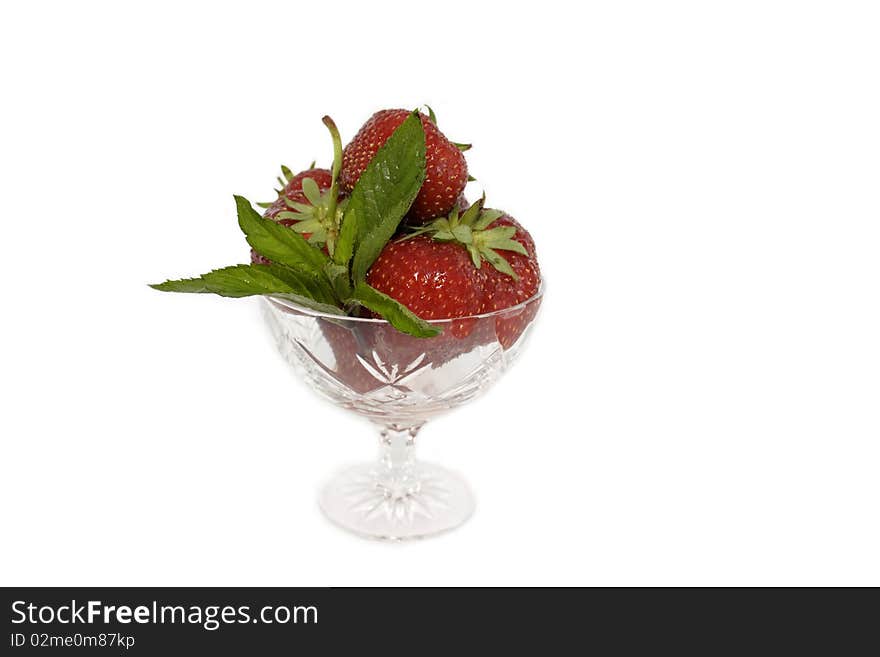 Ripe and juicy strawberries in a glass beaker with mint leaves isolated on white background. Ripe and juicy strawberries in a glass beaker with mint leaves isolated on white background