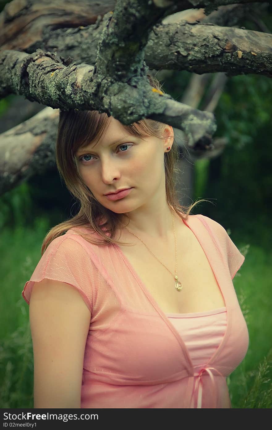 Young woman standing calmly under the tree. Young woman standing calmly under the tree