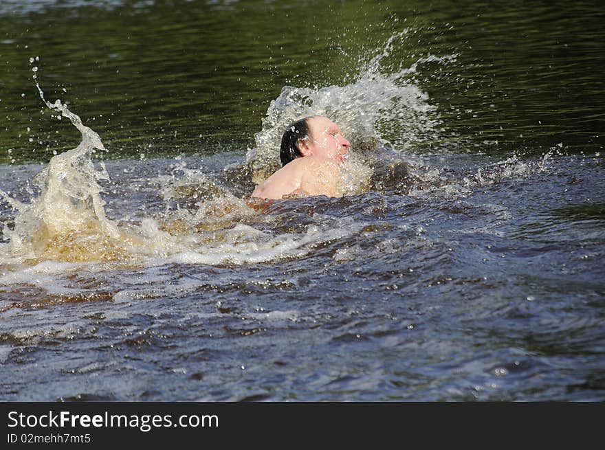 The elderly man floats butterfly stroke in open water. The elderly man floats butterfly stroke in open water