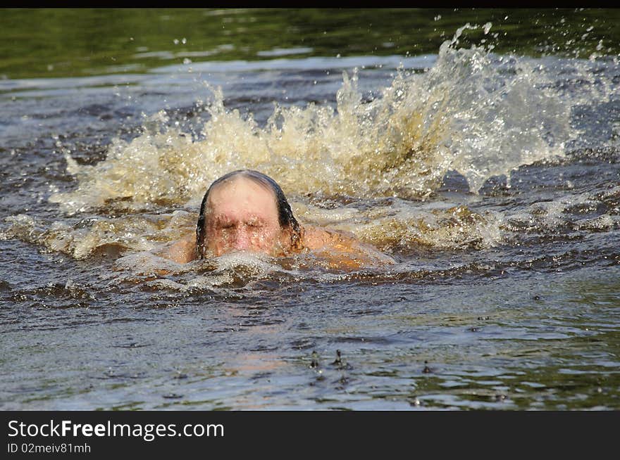 The elderly man floats butterfly stroke in open water. The elderly man floats butterfly stroke in open water