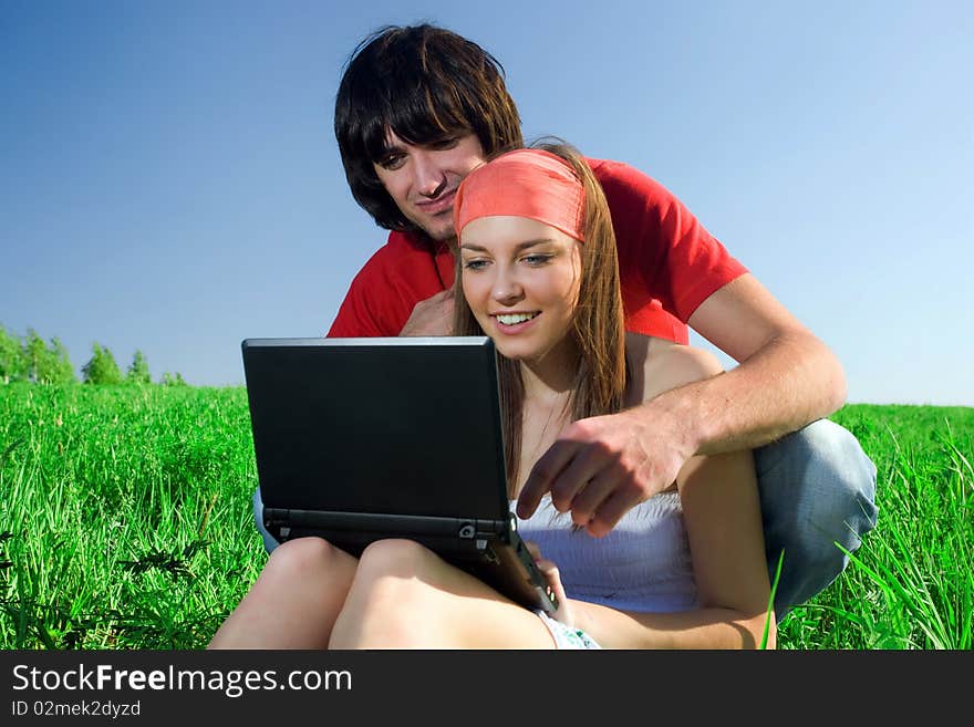 Long-haired girl with notebook and boy on grass