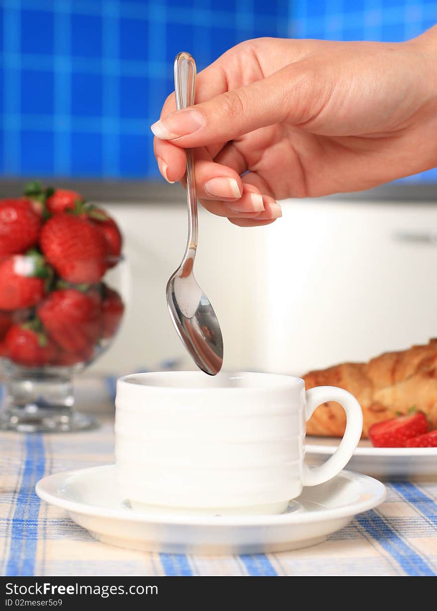 Breakfast. Hand with spoon and cup of coffee. Breakfast. Hand with spoon and cup of coffee.