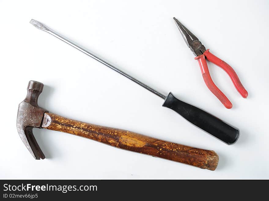 Pliers, screwdriver, and a hammer on white. Pliers, screwdriver, and a hammer on white.