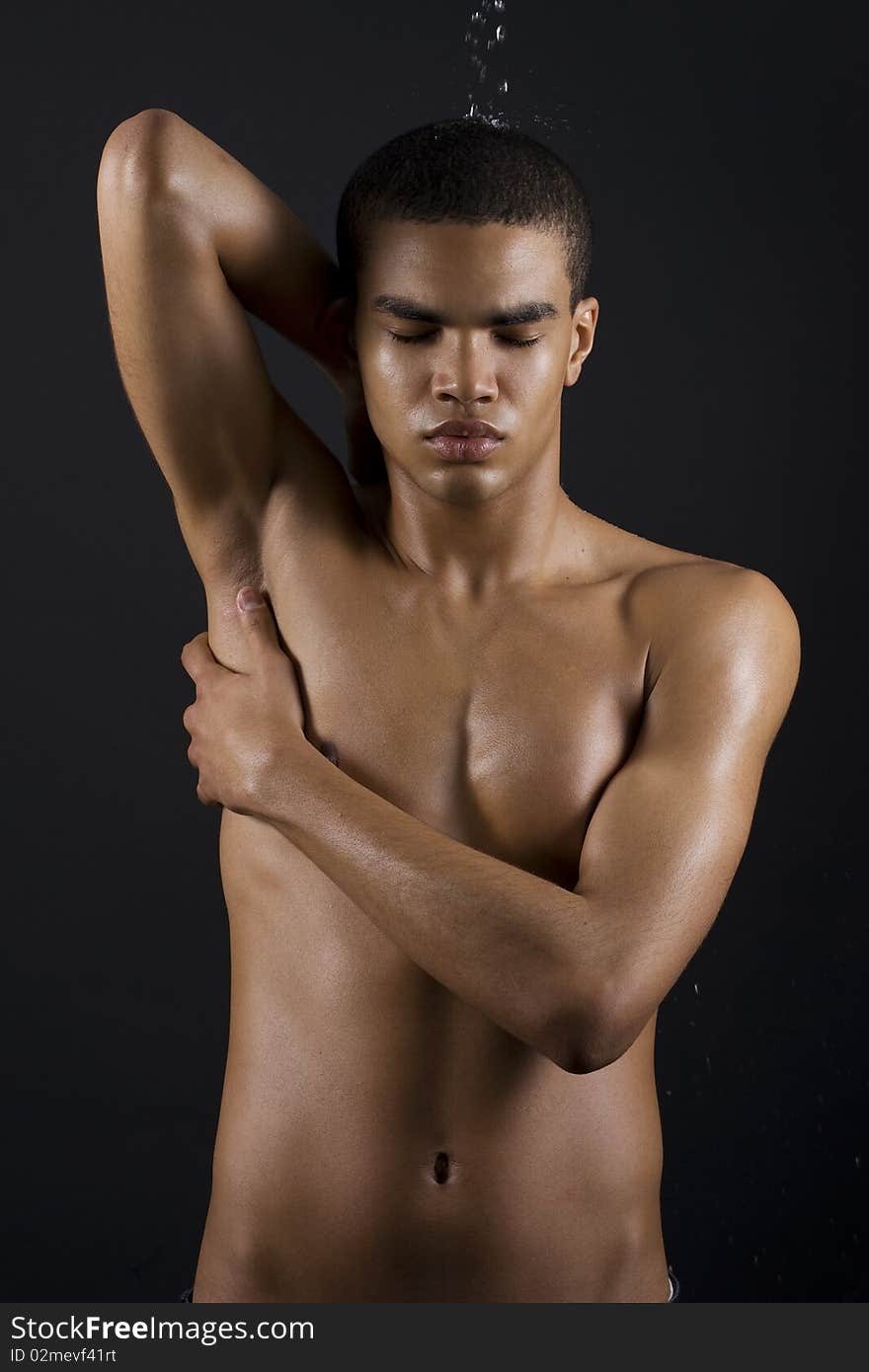 Drops of the water on naked body of a young man on black background. Drops of the water on naked body of a young man on black background.