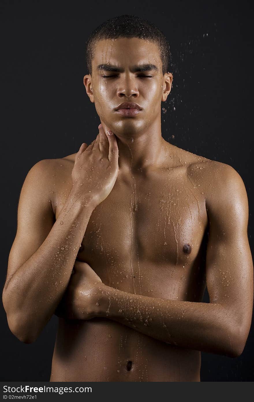 Drops of the water on naked body of a young man on black background. Drops of the water on naked body of a young man on black background.