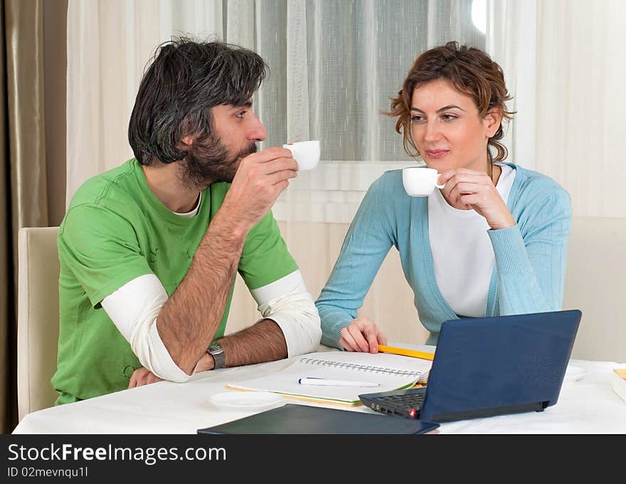 Young man and woman take a break from studying in front of the computer to have some coffee and a chat. Young man and woman take a break from studying in front of the computer to have some coffee and a chat.