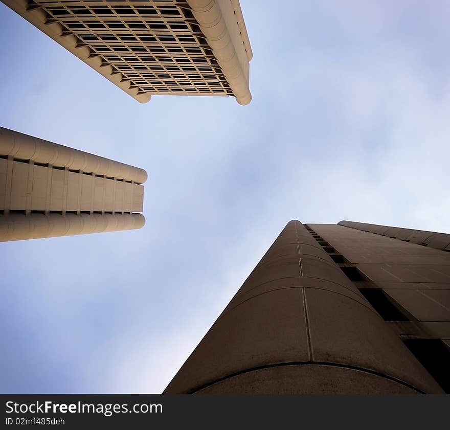 Three high-rise buildings pointing towards the sky in an asymmetric perspective against the sunset. Three high-rise buildings pointing towards the sky in an asymmetric perspective against the sunset