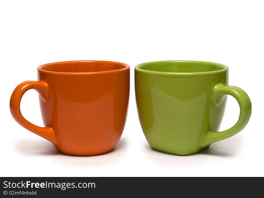 Two cups of different colour on a white background. It is isolated.