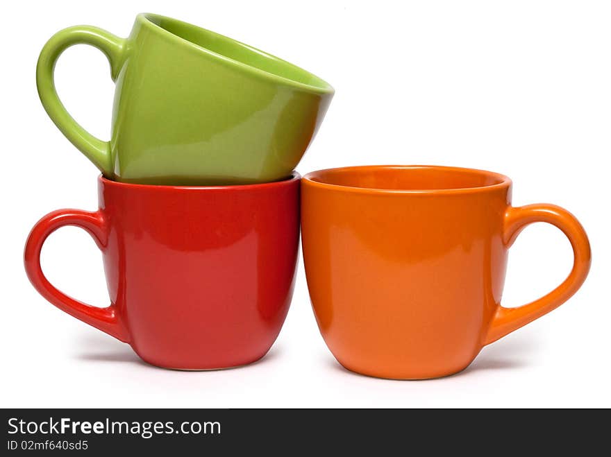 Three cups of various colour on a white background. It is isolated.