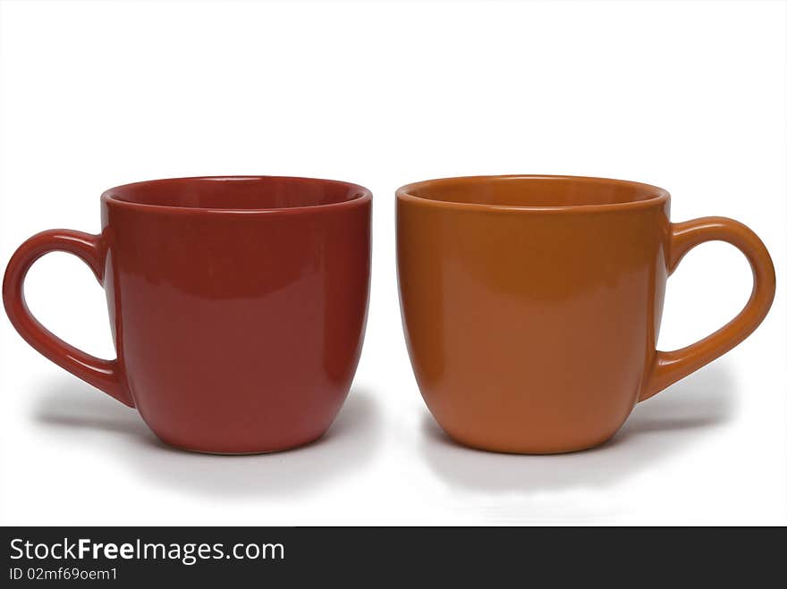 Two cups of different colour on a white background. It is isolated.