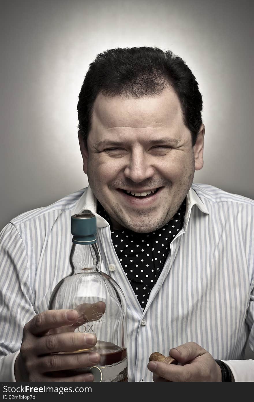 Handsome Man Smiling With A Bottle Of Cognac.