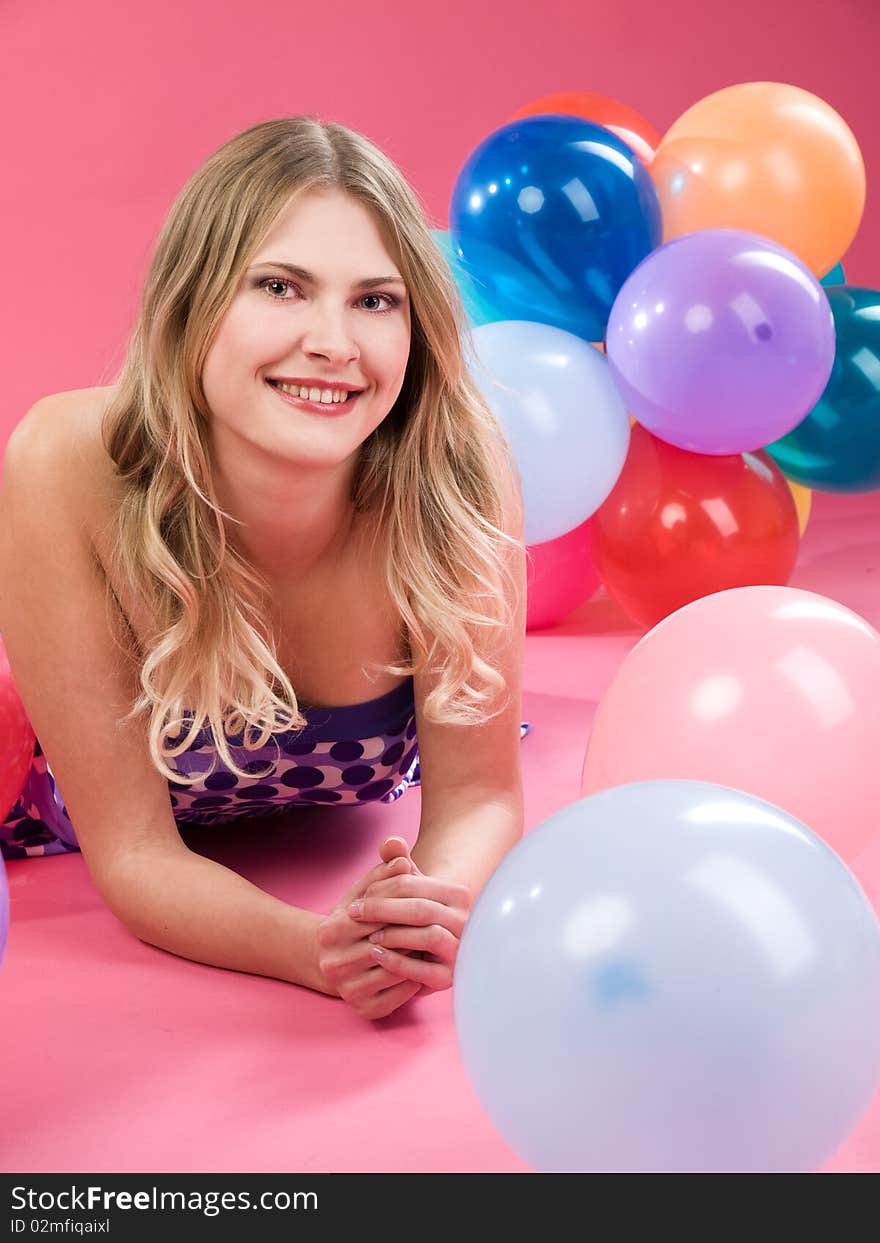 Pretty woman with colorful balloons on pink background. Pretty woman with colorful balloons on pink background