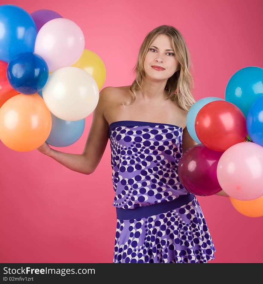 Pretty woman with colorful balloons on pink background. Pretty woman with colorful balloons on pink background