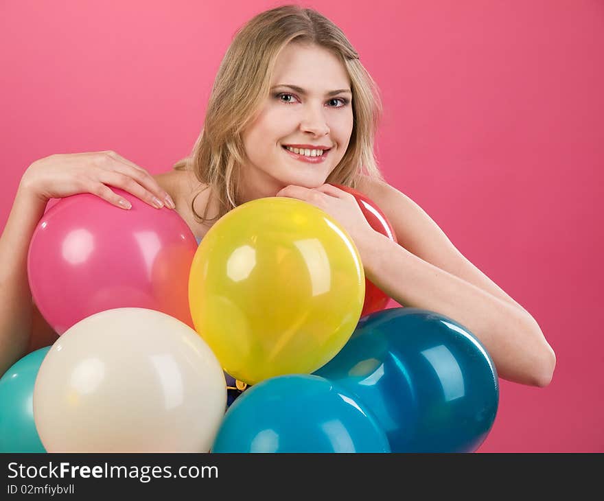 Pretty woman with colorful balloons on pink background. Pretty woman with colorful balloons on pink background