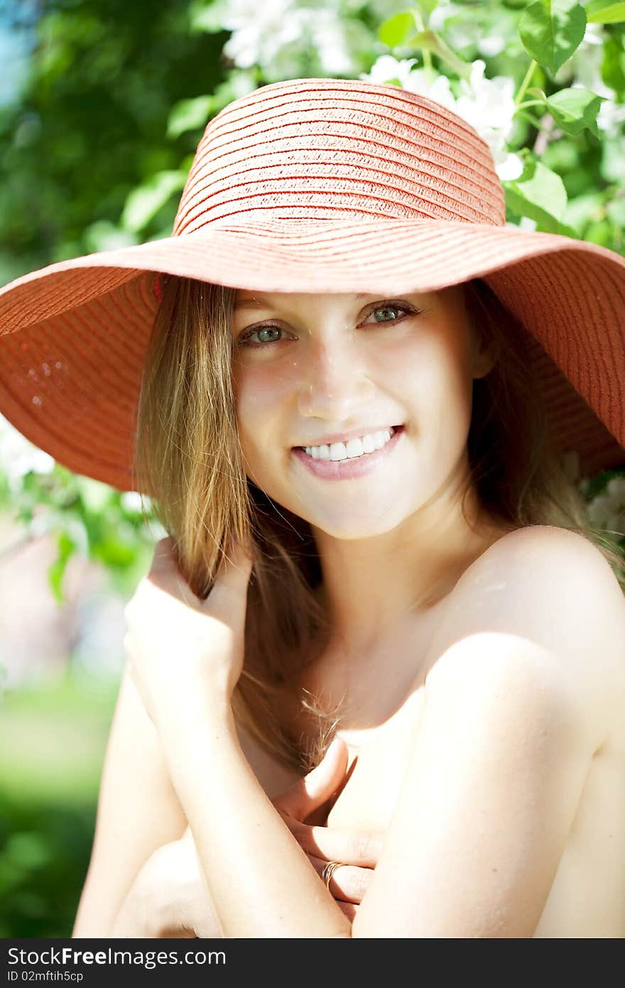 Beautiful half-naked woman among flowering gardens