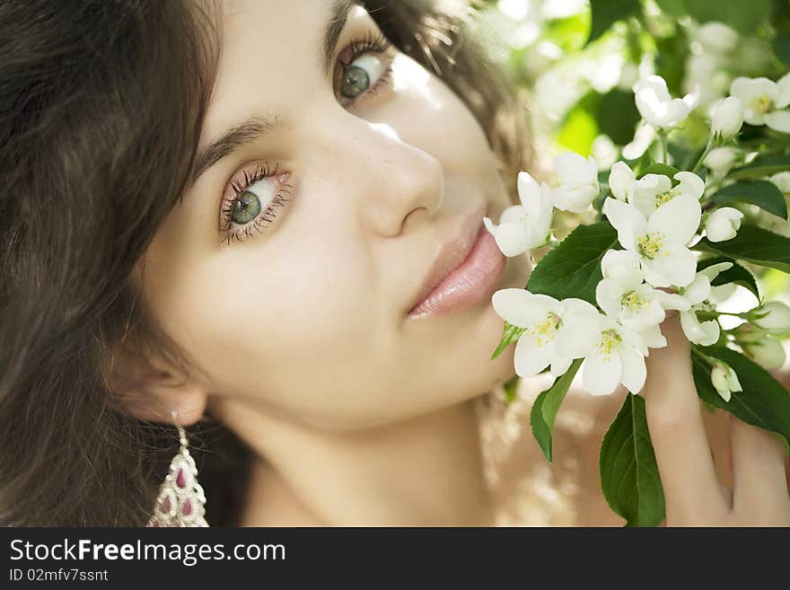 Beautiful girl in the flowered garden