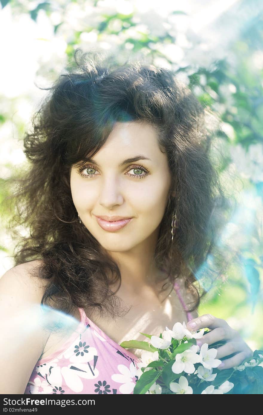 Beautiful girl in the flowered garden