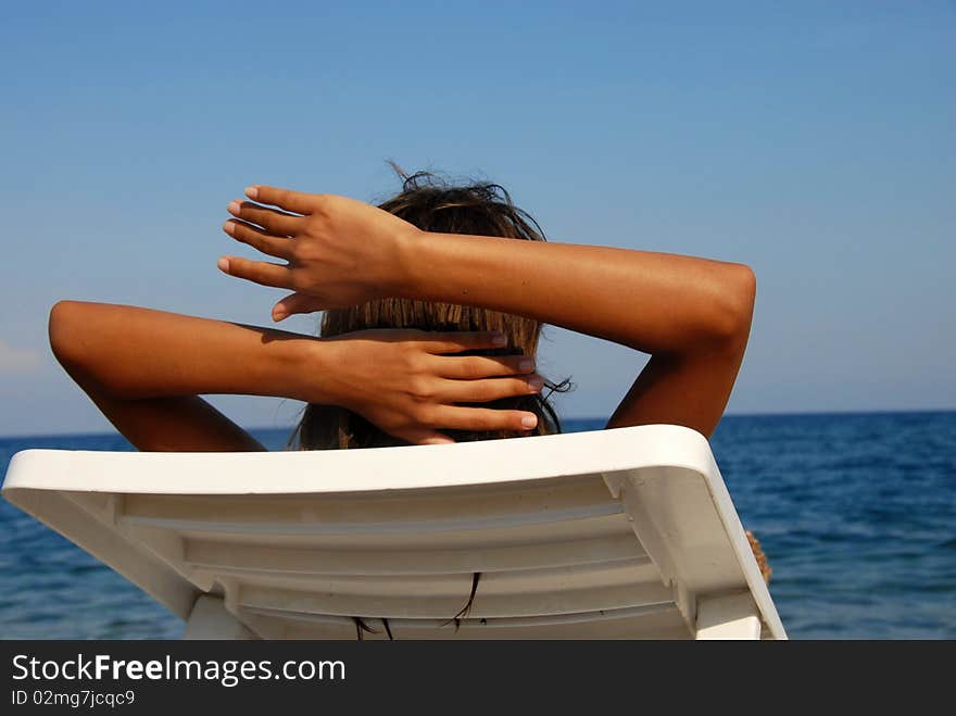 Young girl lying on beach looking at sea view. Young girl lying on beach looking at sea view