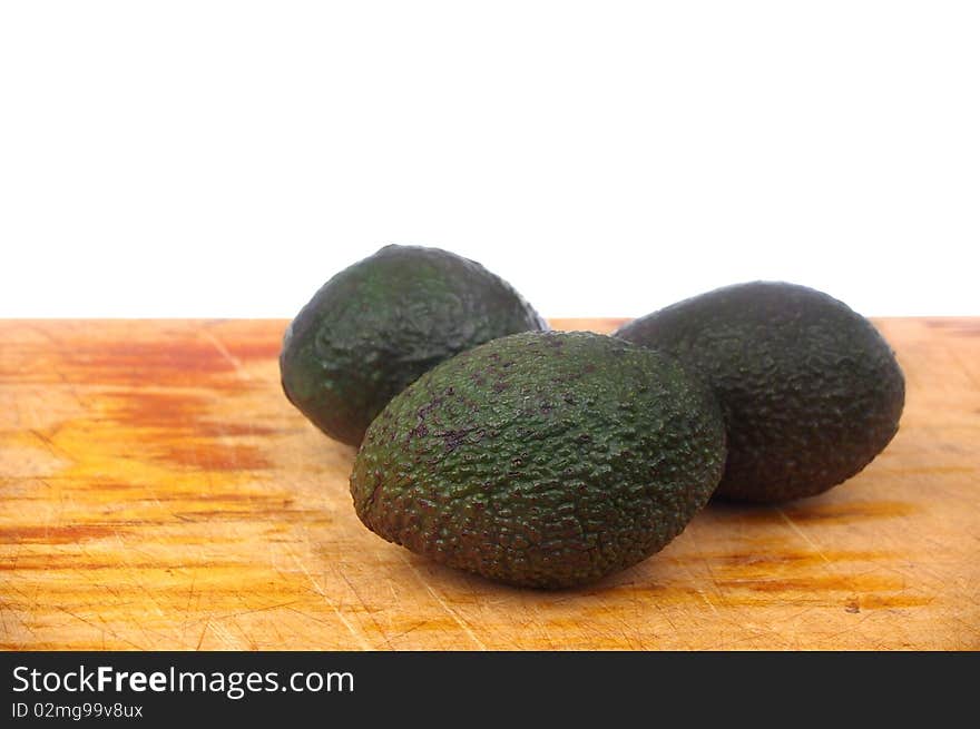 Whole avocado black skin variety over white isolated on board