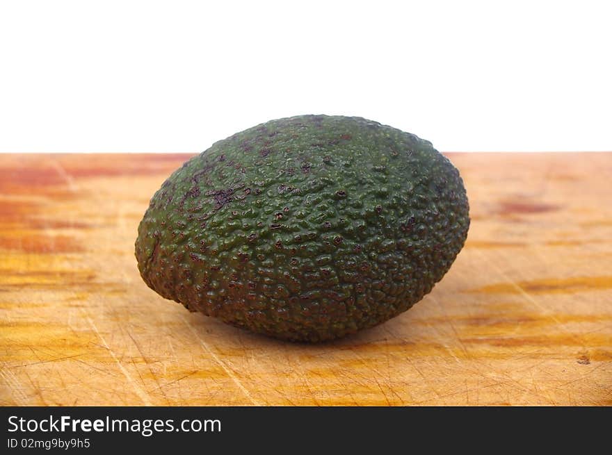 Whole avocado black skin variety over white isolated on board