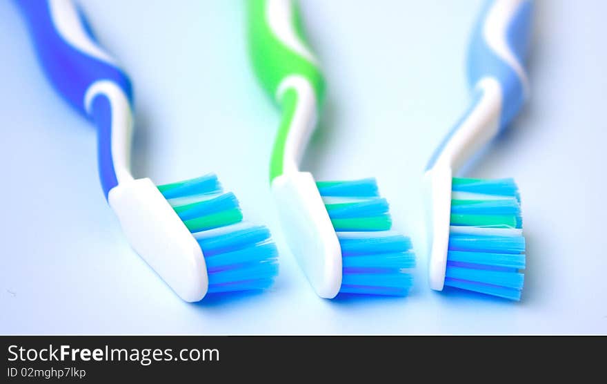 Three tooth-brushes of different colours