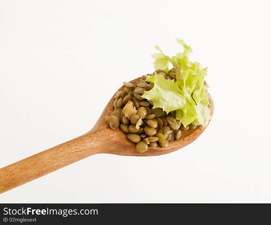 Cooked lentils on a wooden spoon - detail