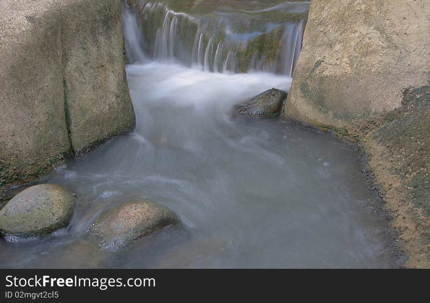 Stream of water flowing down river passing through rocks. Stream of water flowing down river passing through rocks.