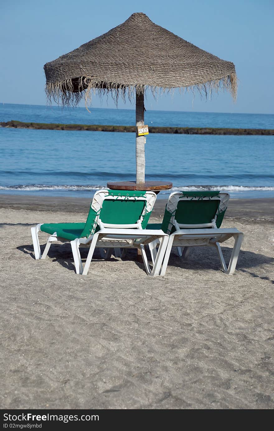 Beach Umbrella And Two Loungers