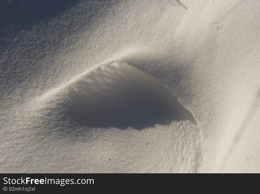 A small snow drift with a shadow.