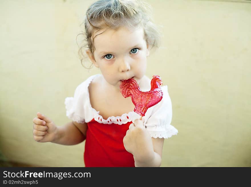 An image of a little girl with sweet red lollipop