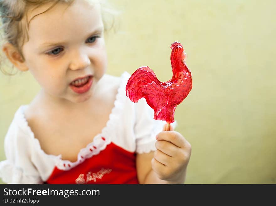 An image of a little girl with sweet red lollipop