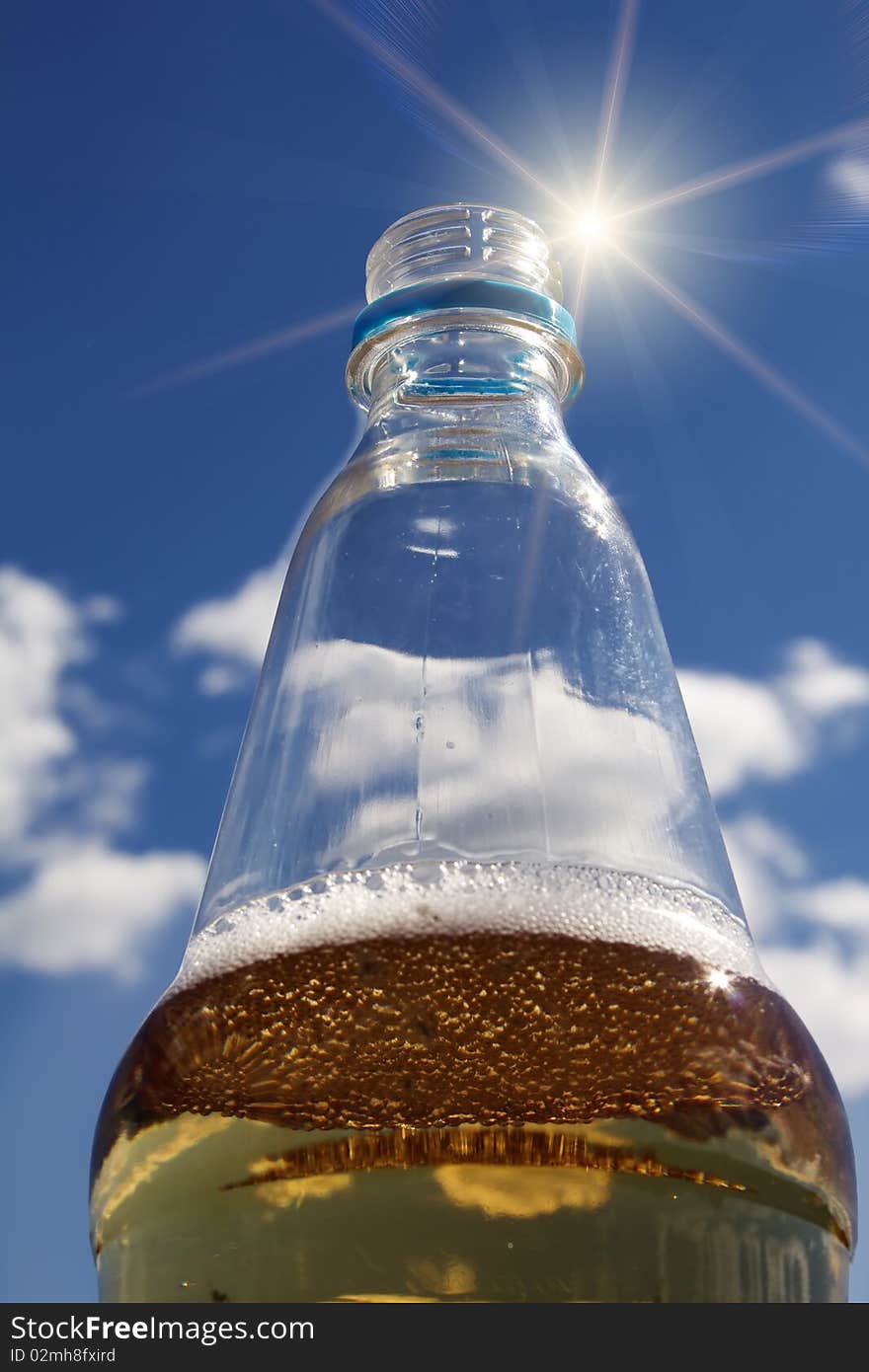 Drink bottle cooling cold sun big against the sky. Drink bottle cooling cold sun big against the sky