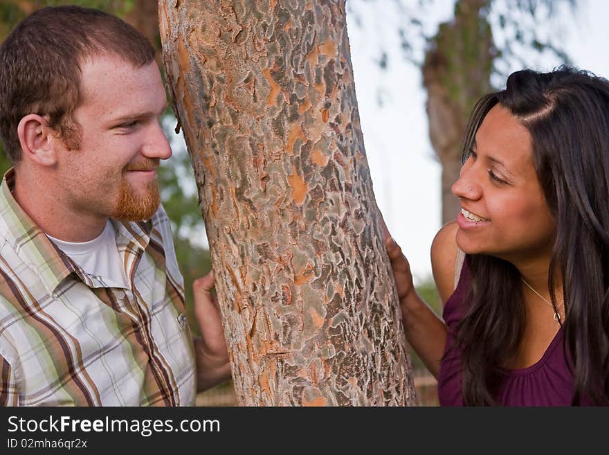 A young couple smiling together in the park. A young couple smiling together in the park.