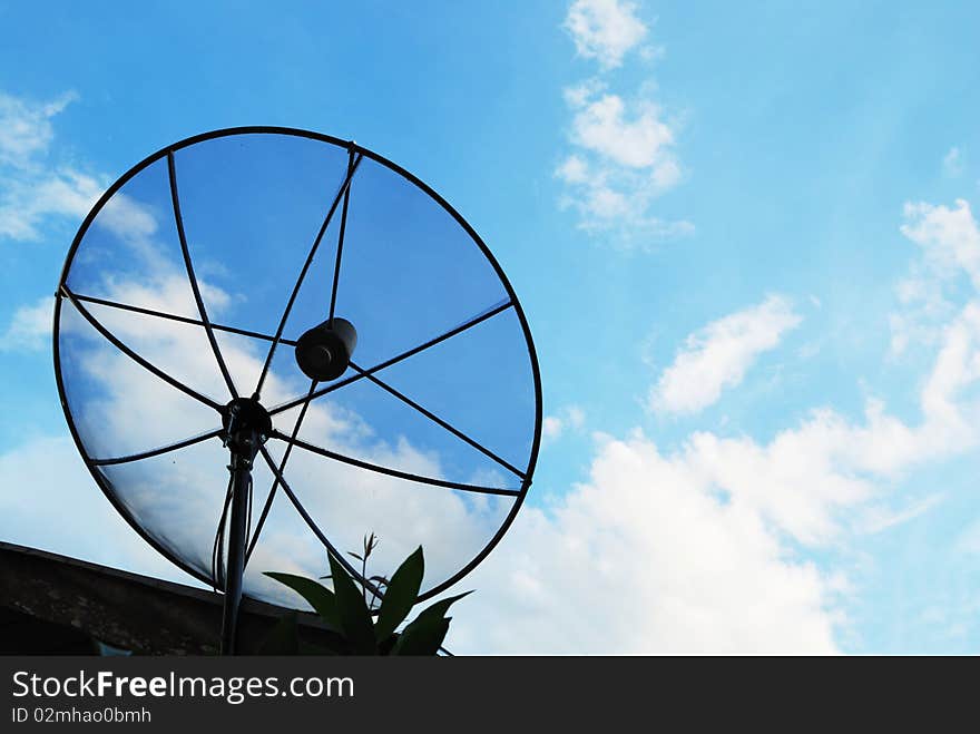 Satellite dish with a cloudy sky