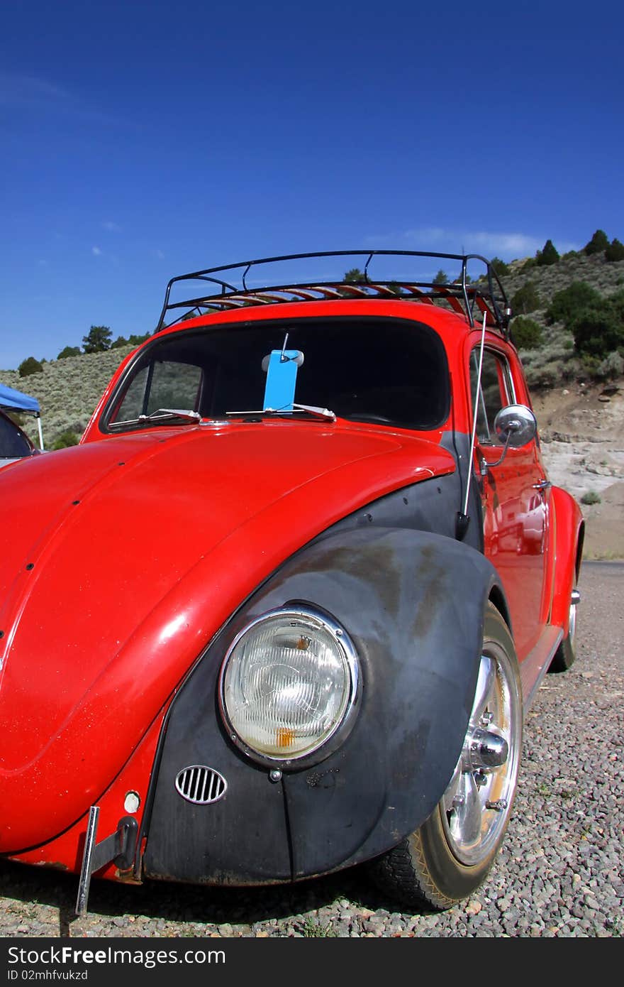 Red classic car against blue sky background